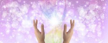 Orbs and sparkles of healing light on a purple background.