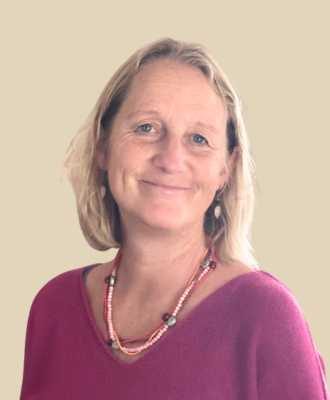 Energy healer Rachel Cremnitz in a pink top and in front of a cream background